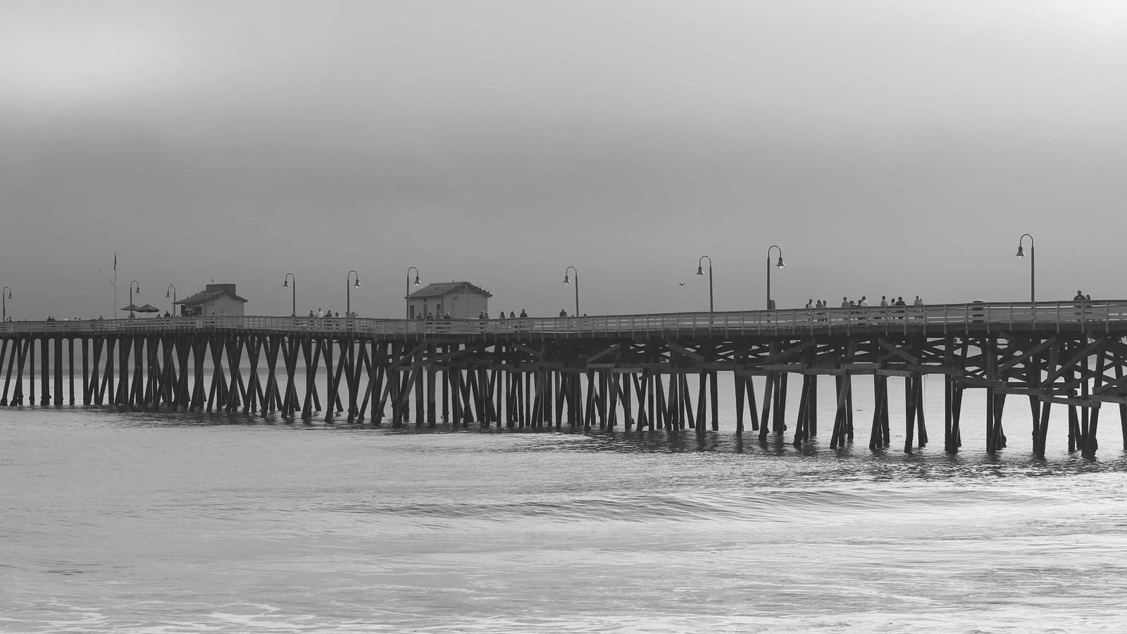 A long pier extending over grey water