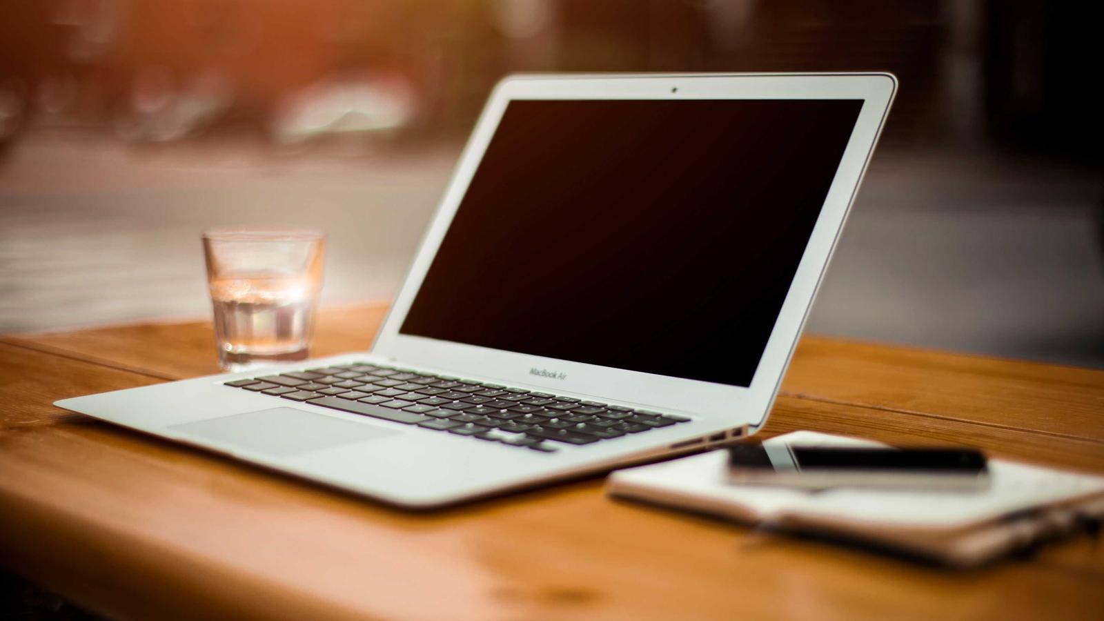 A laptop and coffee on a wooden desk